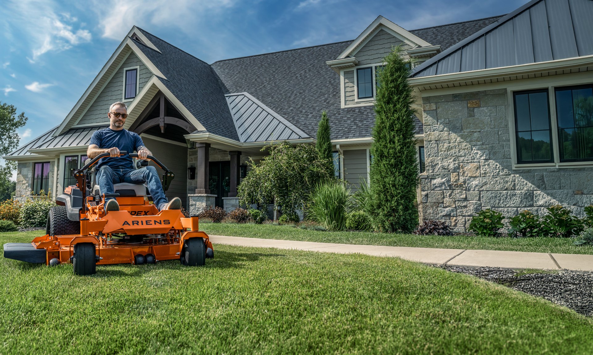 ARIENS zero-turn mower cutting an open lawn at golden hour
